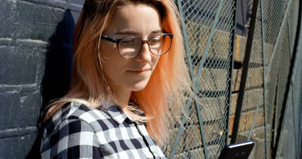 Woman Using Mobile Phone Against the Wall on Sunny Day 4k