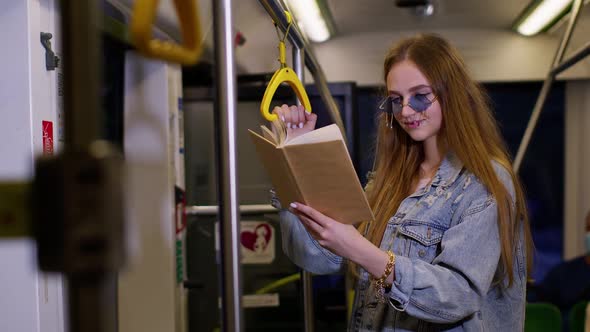 Portrait of Attractive Young Adult Woman Stay at Empty Subway Train and Reading Interesting Book