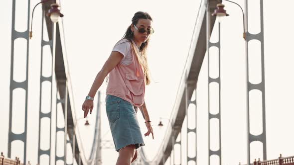 Closeup of Young Female Brunette Skateboarders Performing Complex Tricks on a Skateboard on the City