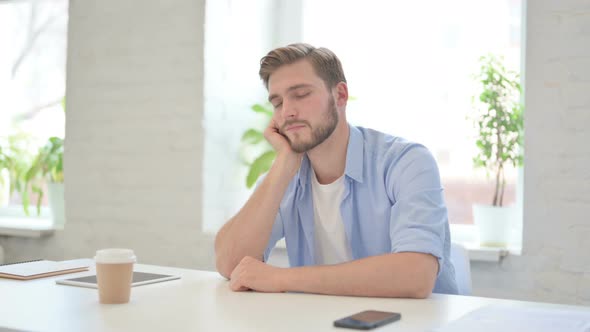 Young Creative Man Taking Nap in Modern Office