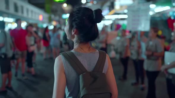 Female walking and eating street food at The Khao San Road.