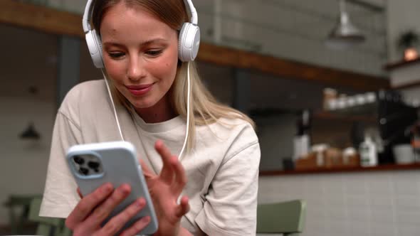Handsome blonde woman in headphones typing by phone