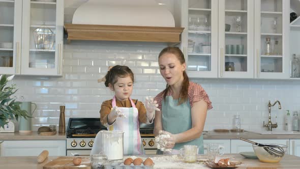 Funny Daughter and Mother Make Dough for Pie at Large Table