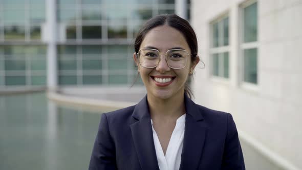 Smiling Businesswoman Looking at Camera and Adjusting Hair