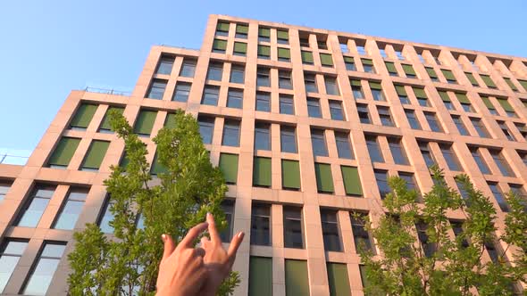 Beautiful Young Girl Dancing on the Street of a Modern Building of a Business Center in the Sunset