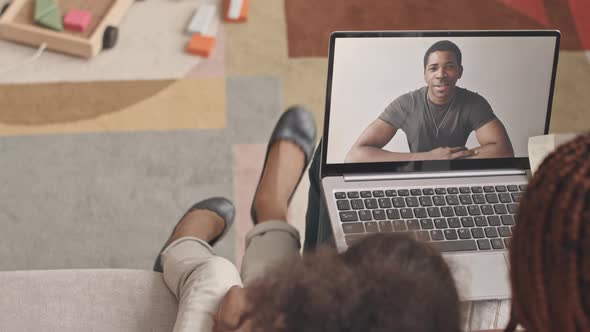 Military Man Video Chatting with Family on Laptop alt