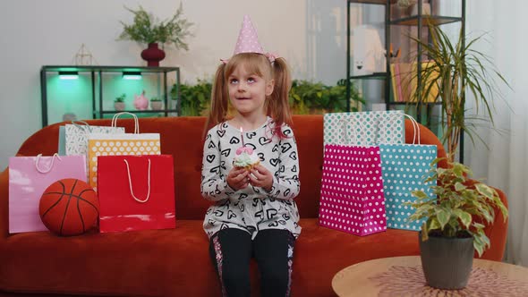 Young Little Children Girl Sitting on Sofa with Lots of Gifts Celebrating Birthday Party Anniversary