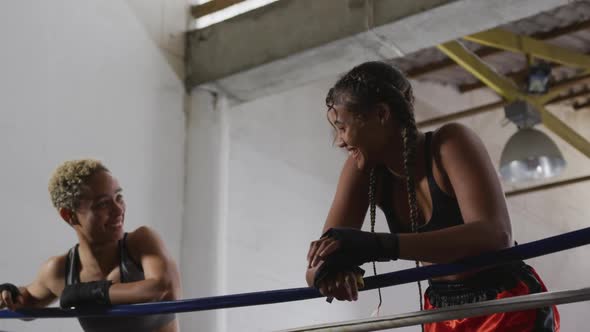 Two mixed race women discussing in boxing ring