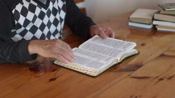 Senior Man Praying Reading an Old Bible in His Hands