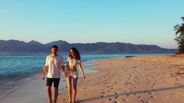 Young boy and girl in love dating on vacation have fun on beach on clean white sand background 4K