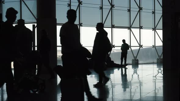 Silhouette of Passing People in Airport Terminal