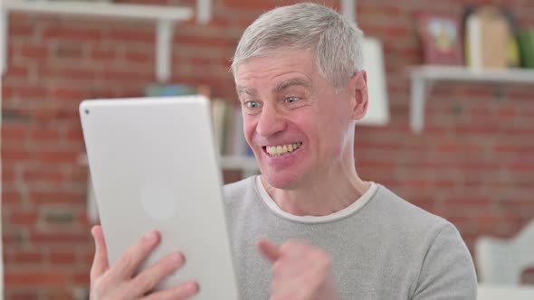 Senior Old Man Celebrating Success on Tablet