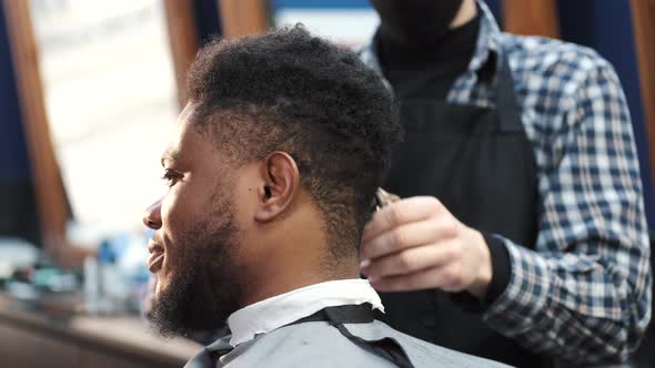 Young Africanamerican Man Visiting Barbershop for Haircut