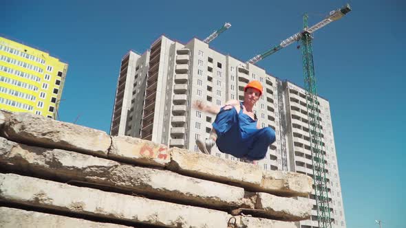 Happy Caucasian Man Builder in Hard Hat Dancing. Worker Funny Moves Background Construction Site.