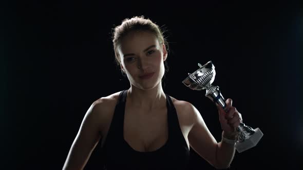 Happy Woman Raising Up Hands with Champion Trophy in Slow Motion