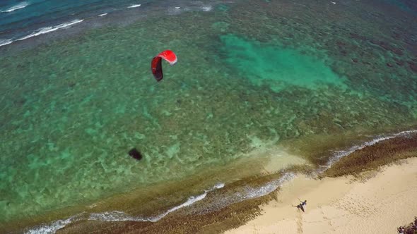 Aerial view of a man kitesurfing in Hawaii.