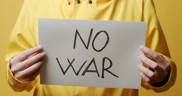 Person holding a white paper with a message No War. We Want No War Message.