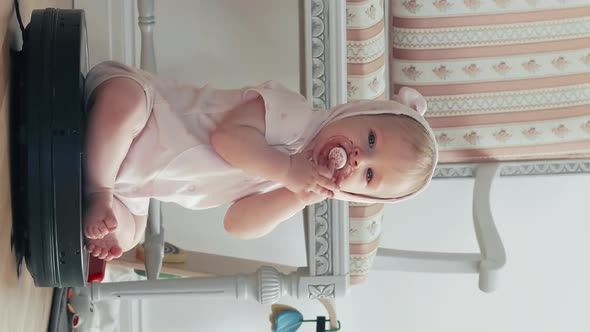 Vertical View of Cute Baby Sitting on Robotic Vacuum Cleaner