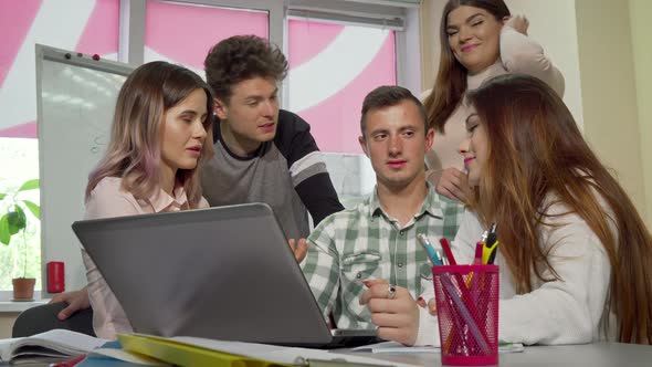 Group of College Friends Laughing and Talking While Studying Together