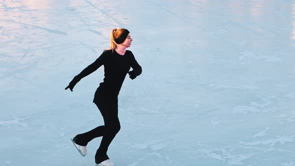 Young Blonde Woman Figure Skating on Public Ice Rink