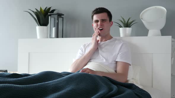 Toothache Man with Tooth Pain Sitting in Bed