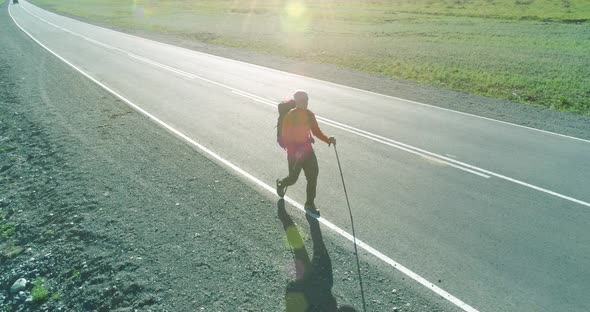 Flight Over Hitchhiker Tourist Walking on Asphalt Road