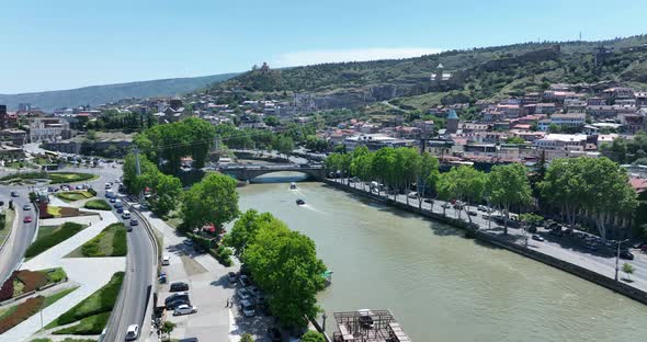 Tbilisi, Georgia - June 7 2022: Flying over  kura river in the center of Tbilisi city