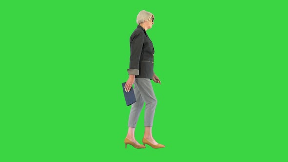 Senior Businesswoman Wearing Glasses Walking on a Green Screen Chroma Key