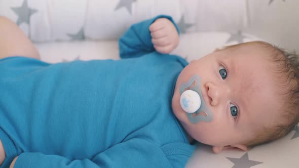 Lovely Baby Sucks Dummy in Cocoon with Star Patterns