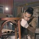 Young Asian man Carpenter uses a tape measure to measure chair on the workbench - VideoHive Item for Sale
