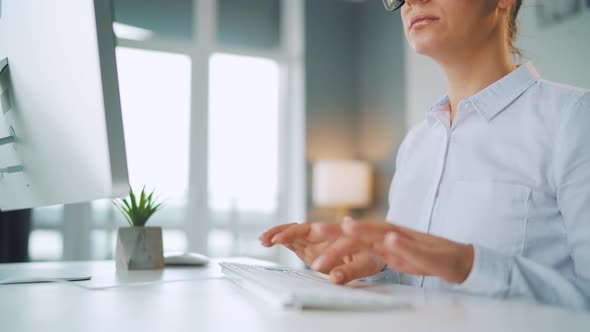 Woman with Glasses Typing on a Computer Keyboard