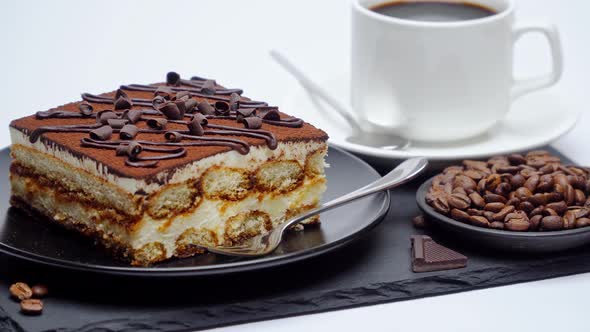 Portion of Traditional Italian Tiramisu dessert and espresso coffee on white background