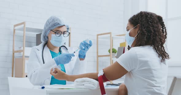 African American Woman Getting Intravenous Meds Injection at Clinic, Professional Medicare Concept