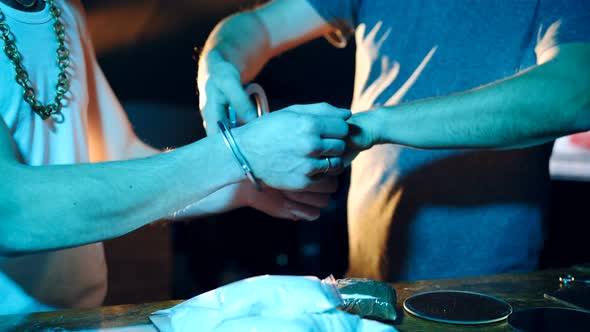 Police Officer Arresting Drug Dealer with Handcuffs