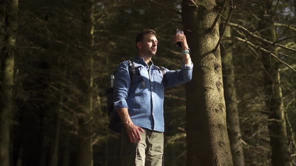 Hiker using smartphone for taking a panoramic photo