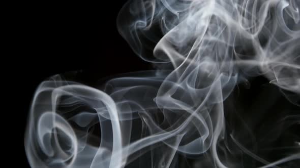 Smoke Slowly Lifts Up On A Black Background