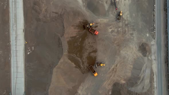 Bulldozers Load Crushed Stone Onto Dump Trucks