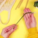 Hands of a young woman holding a metal reusable eco-friendly straw for drinks on a yellow background - VideoHive Item for Sale