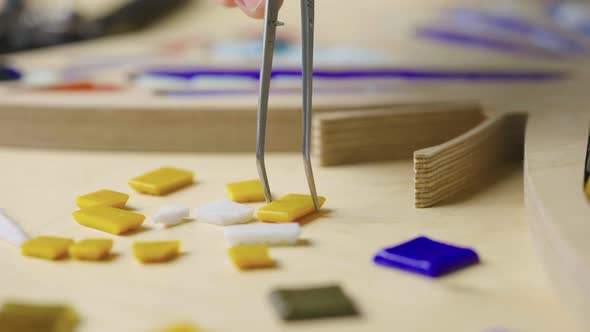 Male Hands Create Mosaics with Tweezers and Bright Little Pieces of Glass and Ceramics