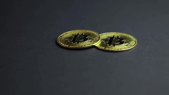 Two Bitcoin coins on dark background with copy space, gold virtual currency