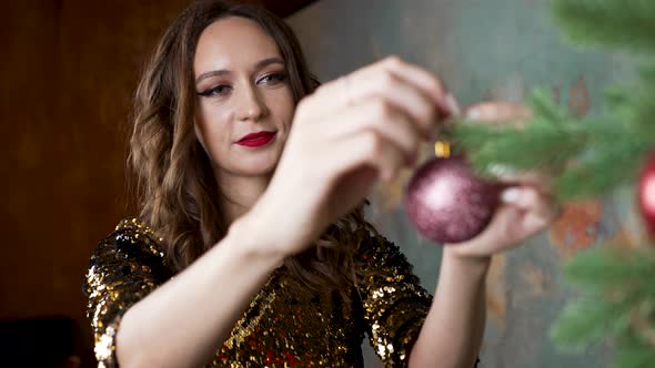 Brunette Woman Decorates Christmas Tree in Living Room