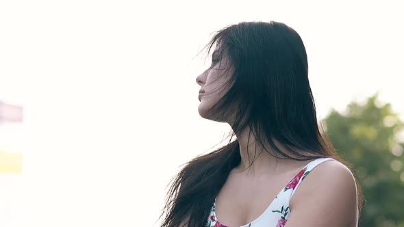 Young Brunette Woman with Loose Flowing Hair Shakes Head