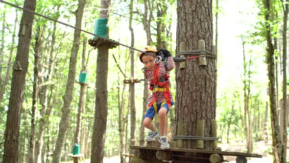 Boy Starts Moving on a Zipline From a Wooden Platform
