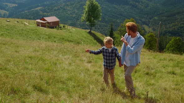 Father Son Enjoy Walk on Green Hill