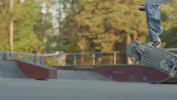 Slowmo of Unrecognizable Teenager Doing Kickflip on Skateboard