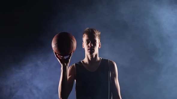 A Male Player Spins a Basketball on His Finger in Slow Motion