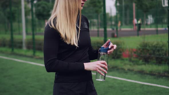 Woman Sportsman Drinks Water