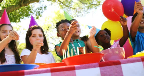 Group of kids playing with sparkler while celebrating a birthday alt