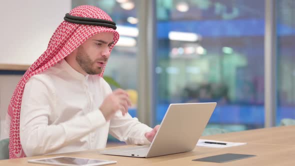 Exhausted Arab Businessman with Laptop Having Headache in Office