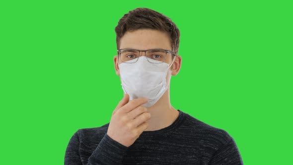 Man in a Disposable Mask and Glasses on a Green Screen, Chroma Key.